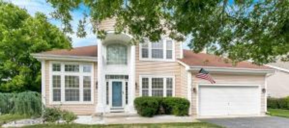 Tan house with front yard and garage
