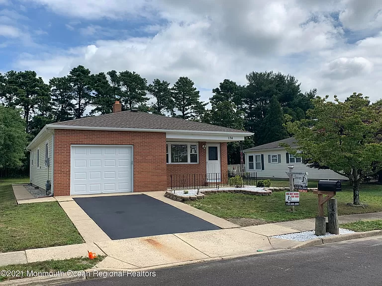 Brick ranch home with a garage and driveway.