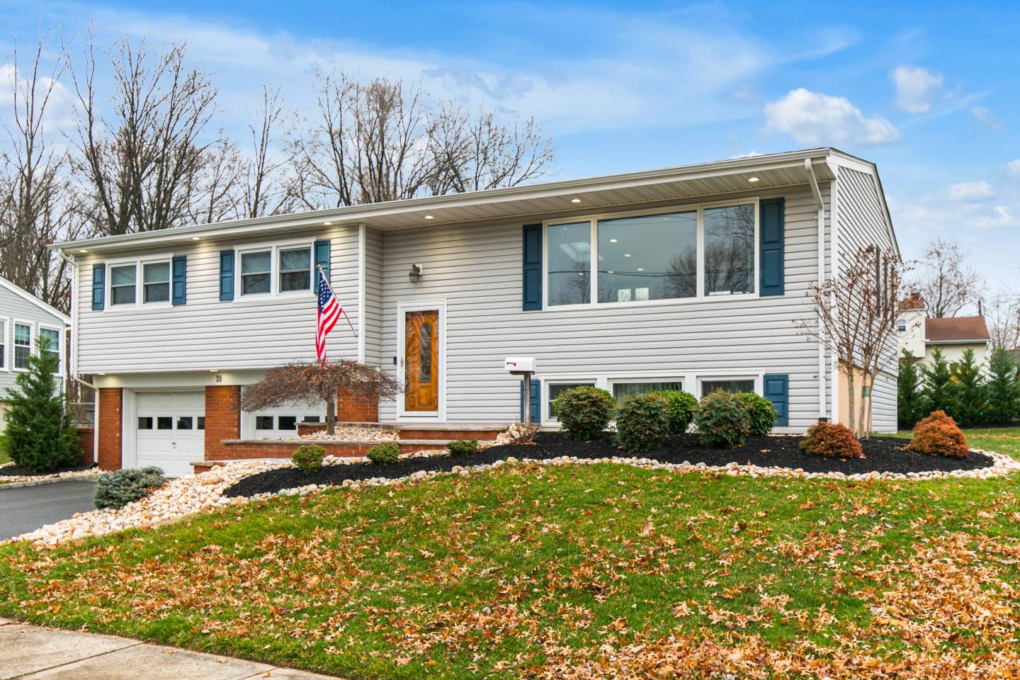 Suburban home with American flag and lawn.