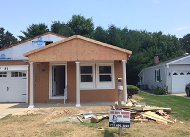 Brown house under construction with white garage door.