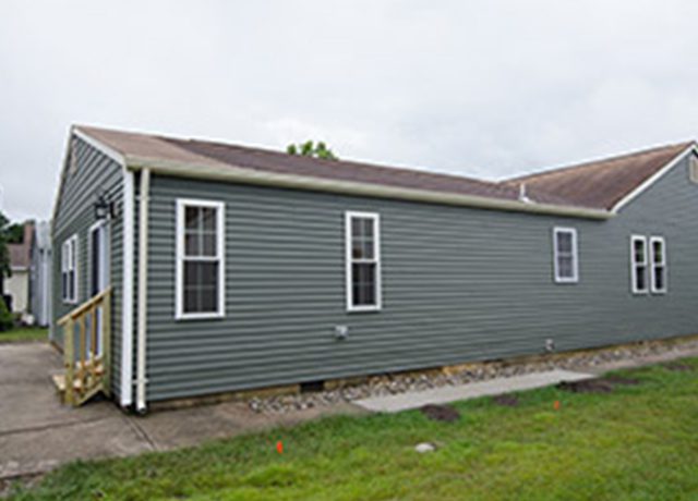 Gray house with a wooden porch.