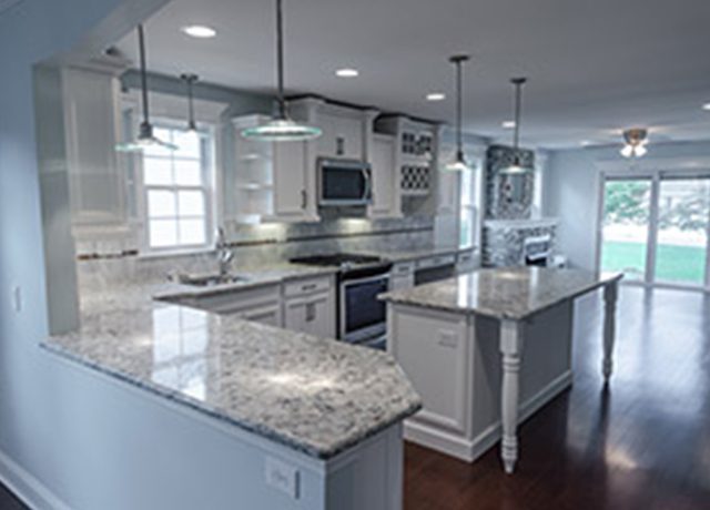 White kitchen island with granite countertop.