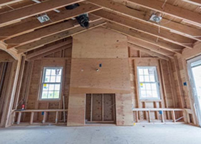 Unfinished room with fireplace and windows.