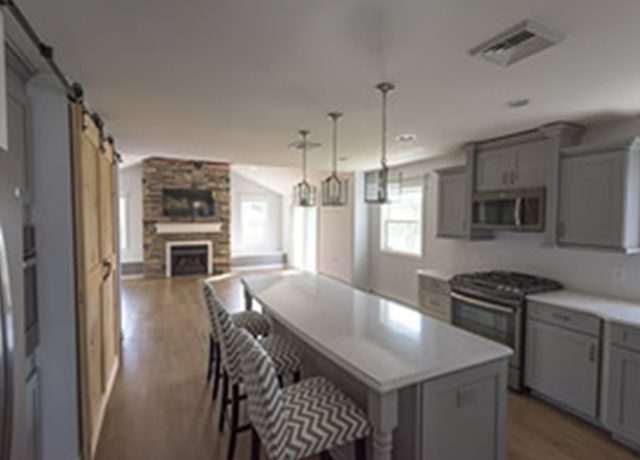 Modern kitchen island with stone fireplace.