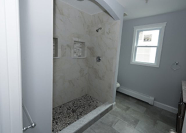 Modern bathroom with tiled shower and floor.