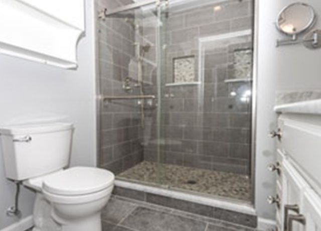 White bathroom with tiled shower stall.