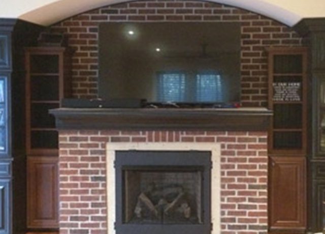 Brick fireplace with built-in shelves and TV.