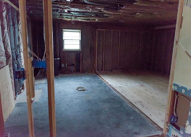 Unfinished basement with wood floor and window.