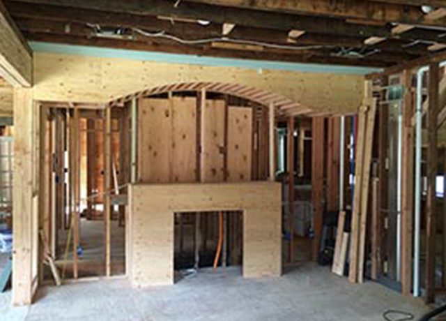 Unfinished room with fireplace framing.