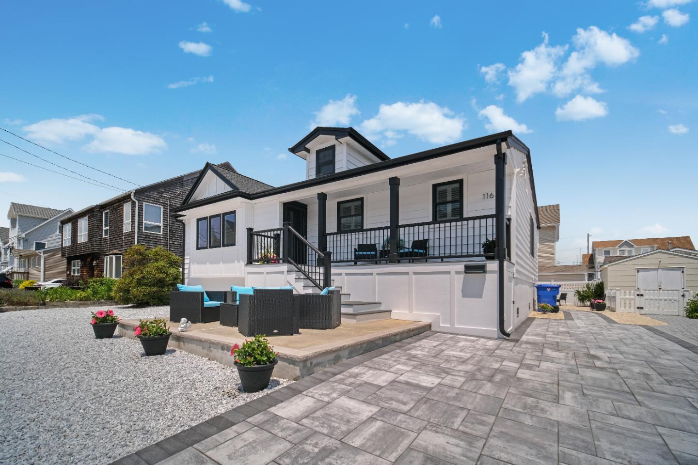 White house with black trim and patio.