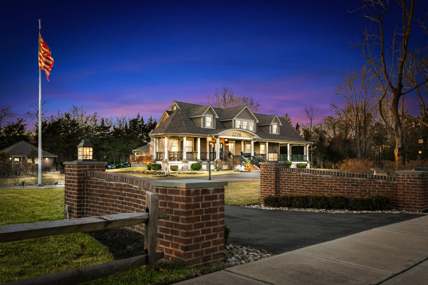 Brick wall with American flag and house.