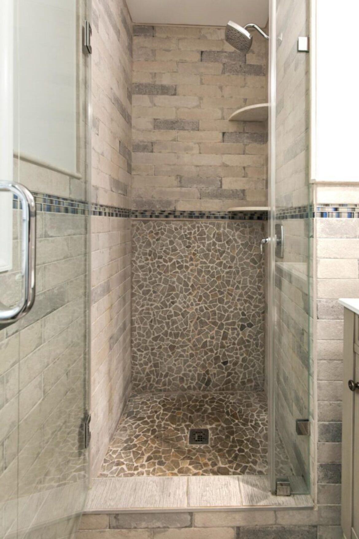 Stone tile shower with glass door.