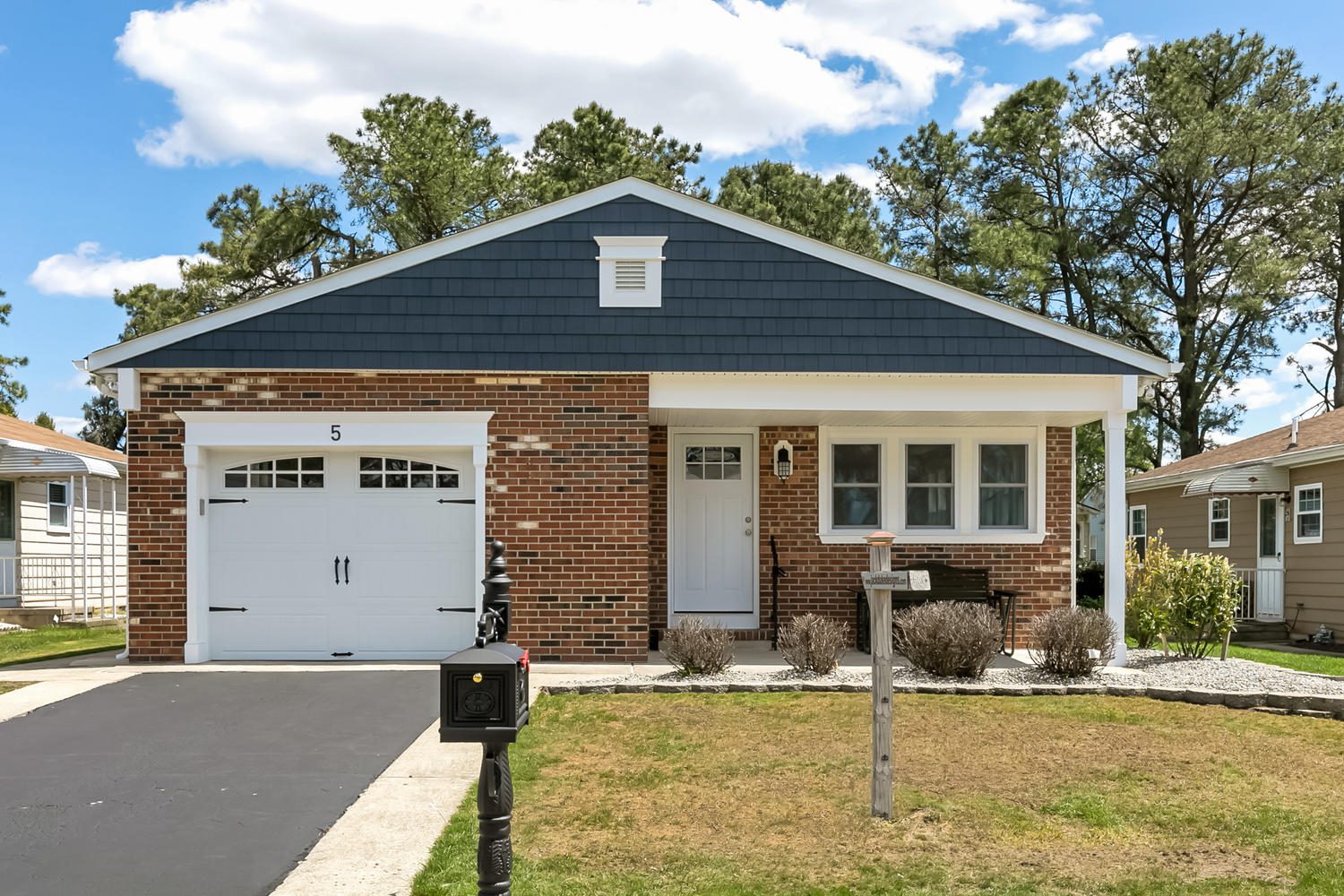 Brick house with white garage door and porch.